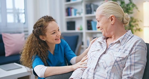 smiling caregiver interacting with elderly woman in a home setting showcasing compassion and connection related to 7 comforting moments