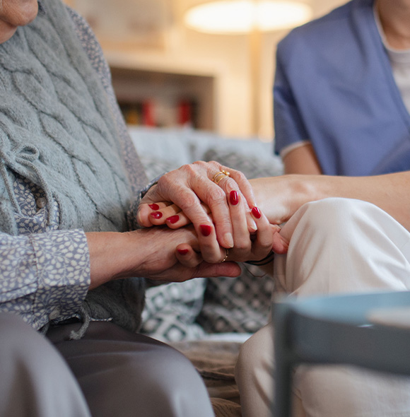 two hands holding gently in a caring environment symbolizing companionship and support for elderly individuals